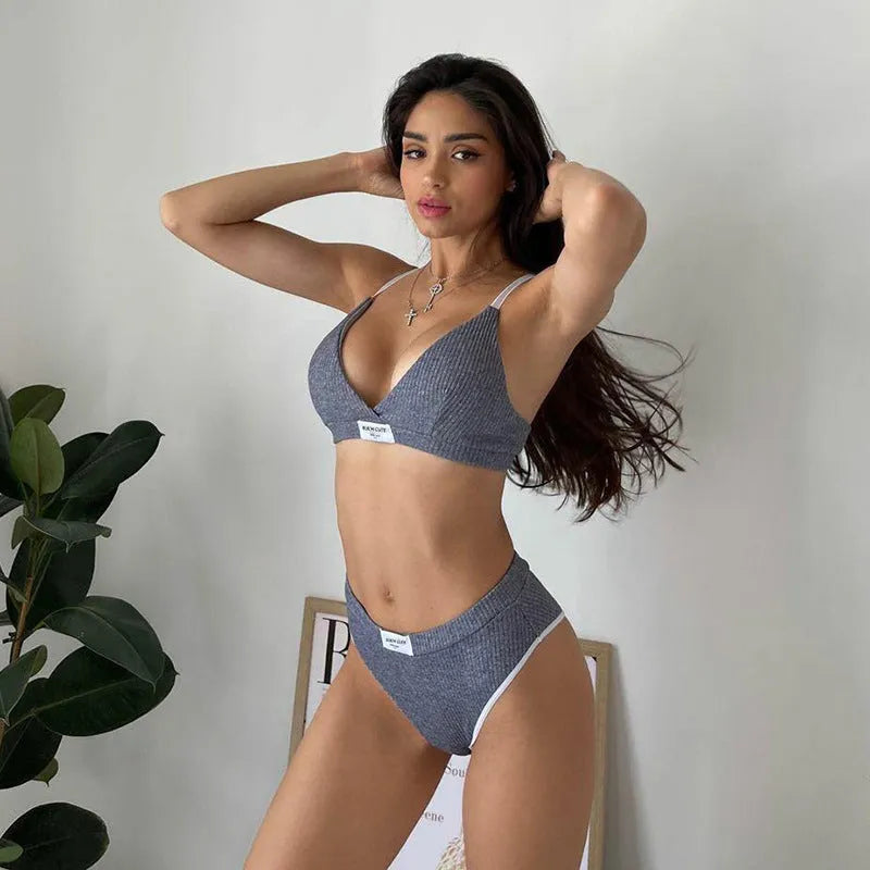 Women's grey bikini set with decorative embroidery and white contrast colour binding on the sleeveless top and shorts.