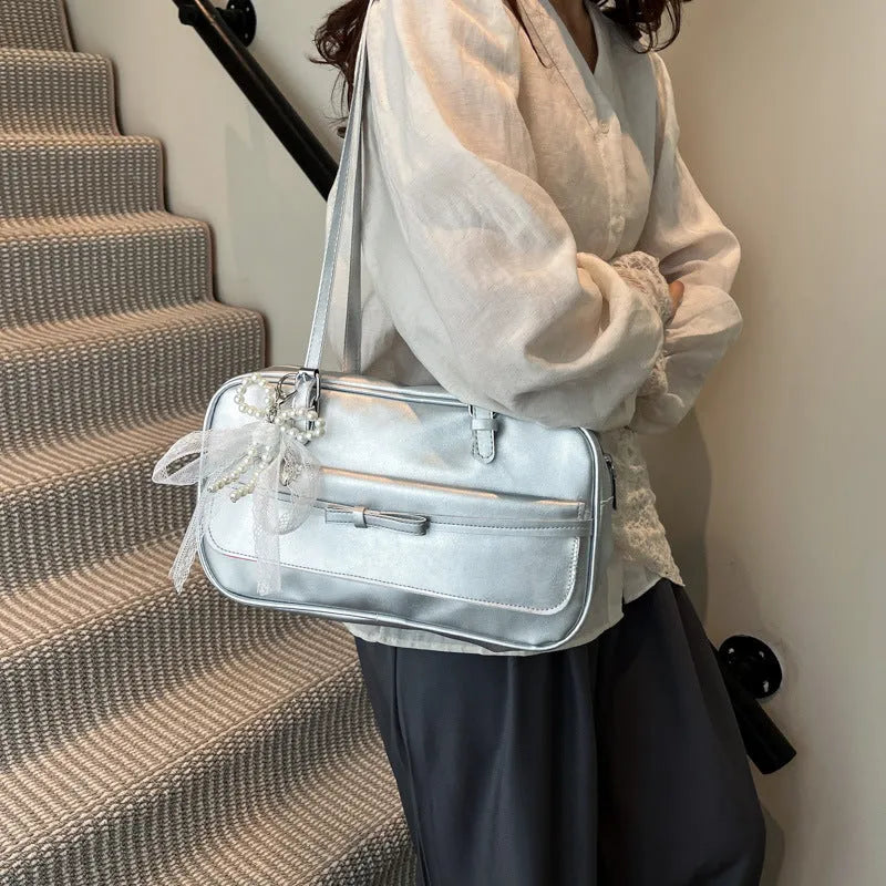 Structured PU leather single-shoulder flap bag in a horizontal square shape with a flap closure.
