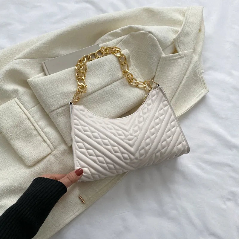 Brown pleated chain baguette women's shoulder bag with adjustable strap on a mannequin.