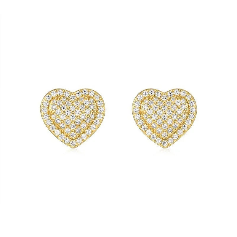 A pair of gold-coloured heart-shaped moissanite stud earrings on a plain background.
