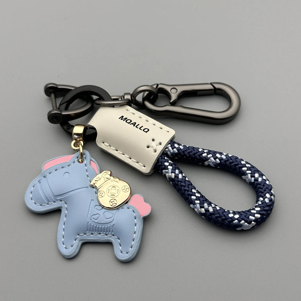 Handmade brown cowhide leather key ring with a gold pony belt buckle charm and a green flanelle rope loop.
