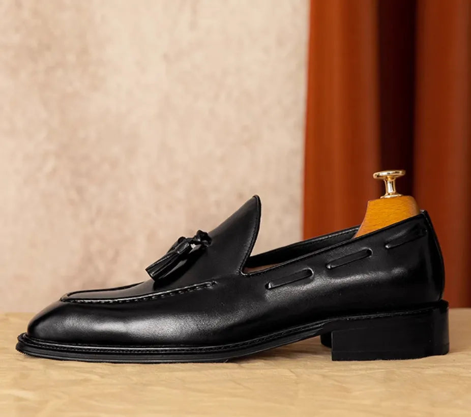 Men's black genuine leather slip-on loafers with fringed detailing on a white background