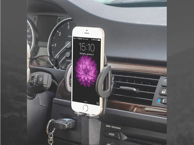 Black car air vent mobile phone holder attached to air conditioning outlet holding smartphone