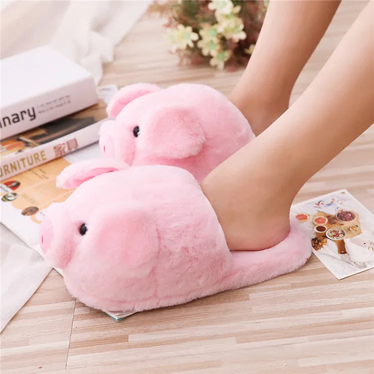 Pink pig-shaped floor slippers with a soft plush fabric exterior.