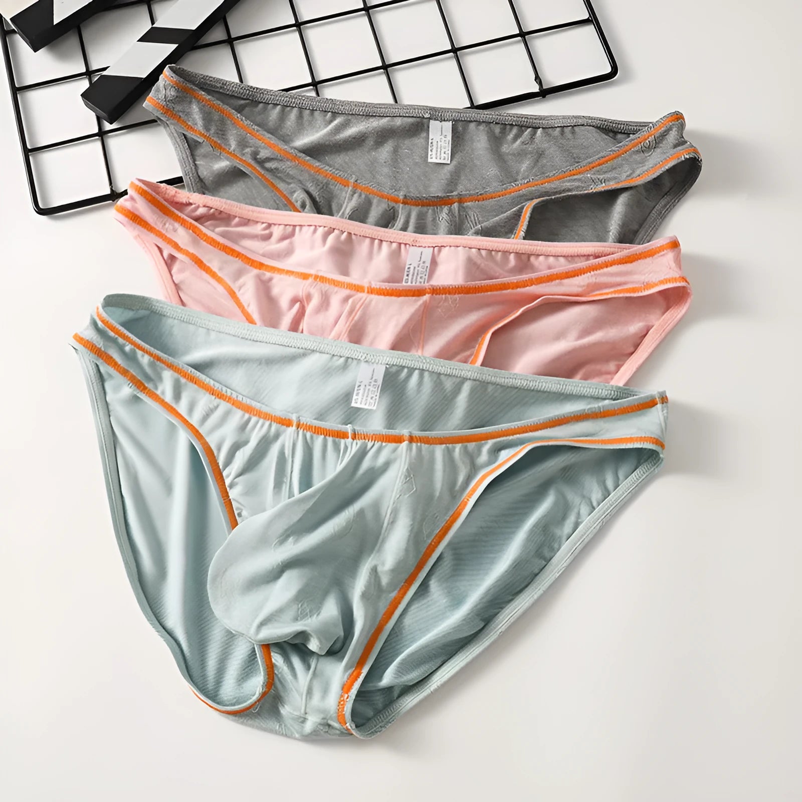 Men's dark grey modal hip-lift underwear laid flat, showing knitted ice silk fabric texture.