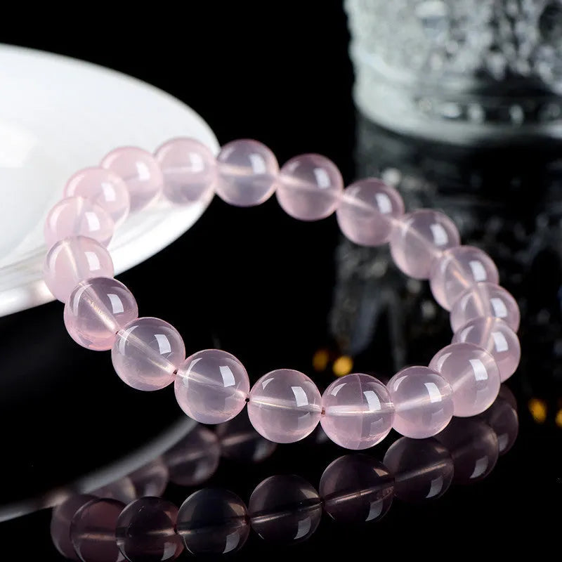 Natural Starlight Crystal round bead bracelet in pink, showing polished finish on wrist.