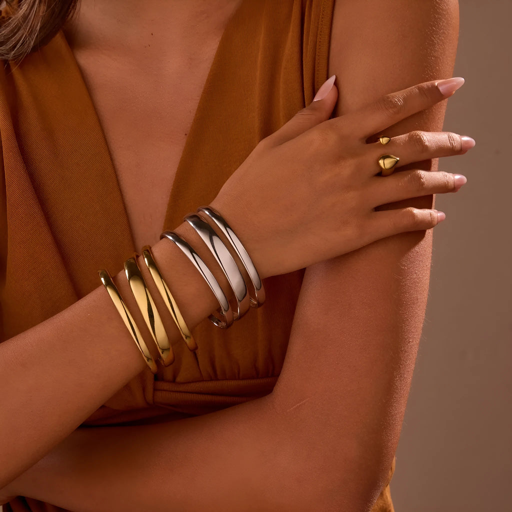 Women's stainless steel bracelet with geometric line design, shown in gold and steel finish options.