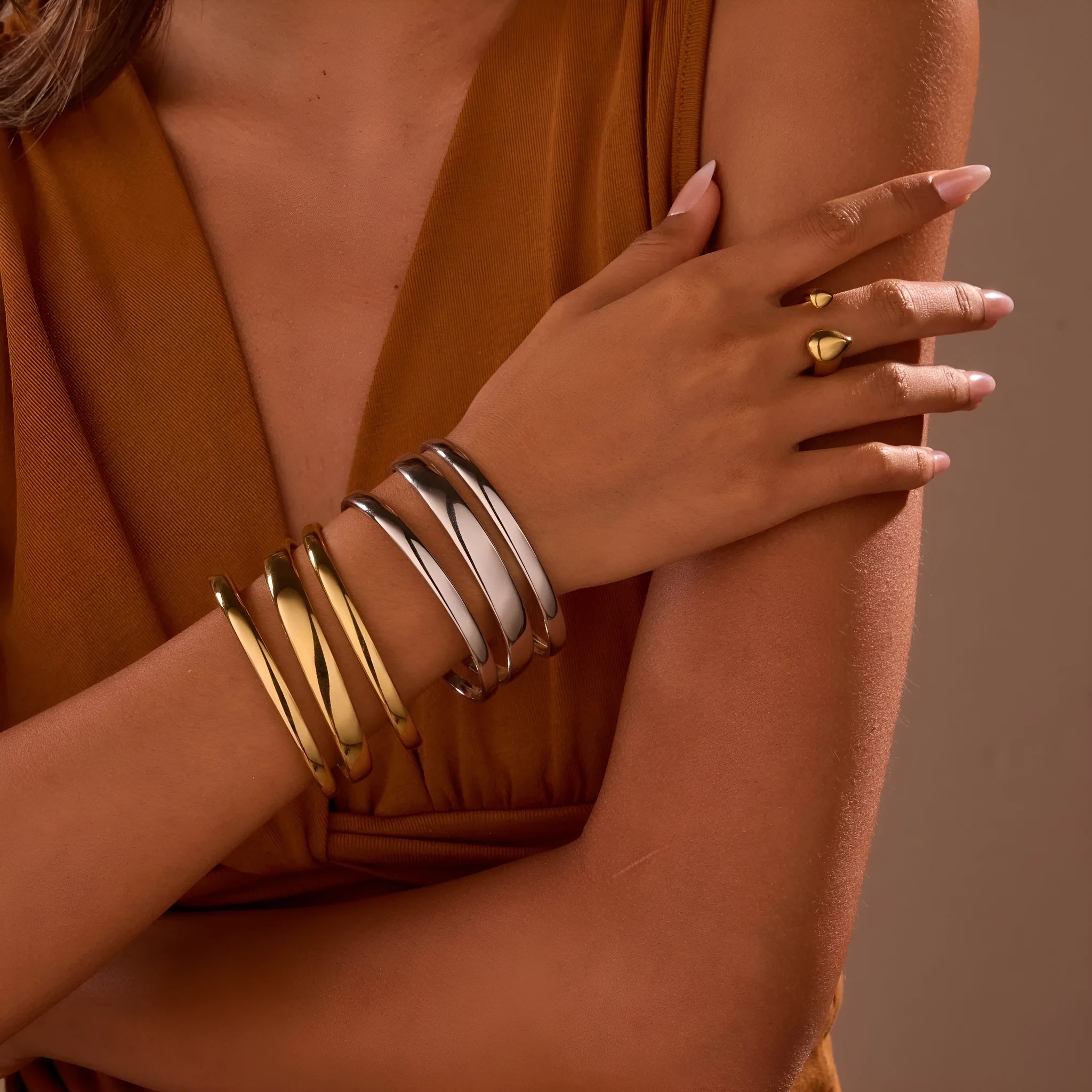 Women's stainless steel bracelet with geometric line design, shown in gold and steel finish options.
