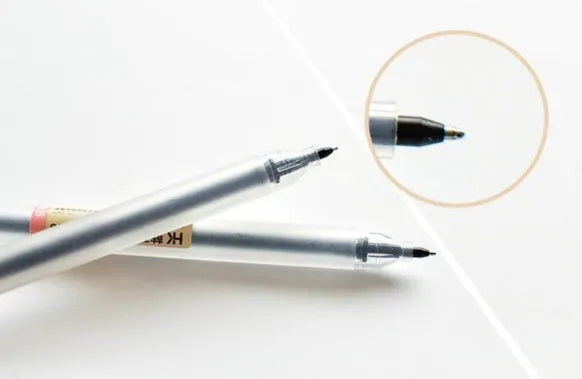 Pack of 12 black Muji gel pens with 0.5mm fine nibs on a white background