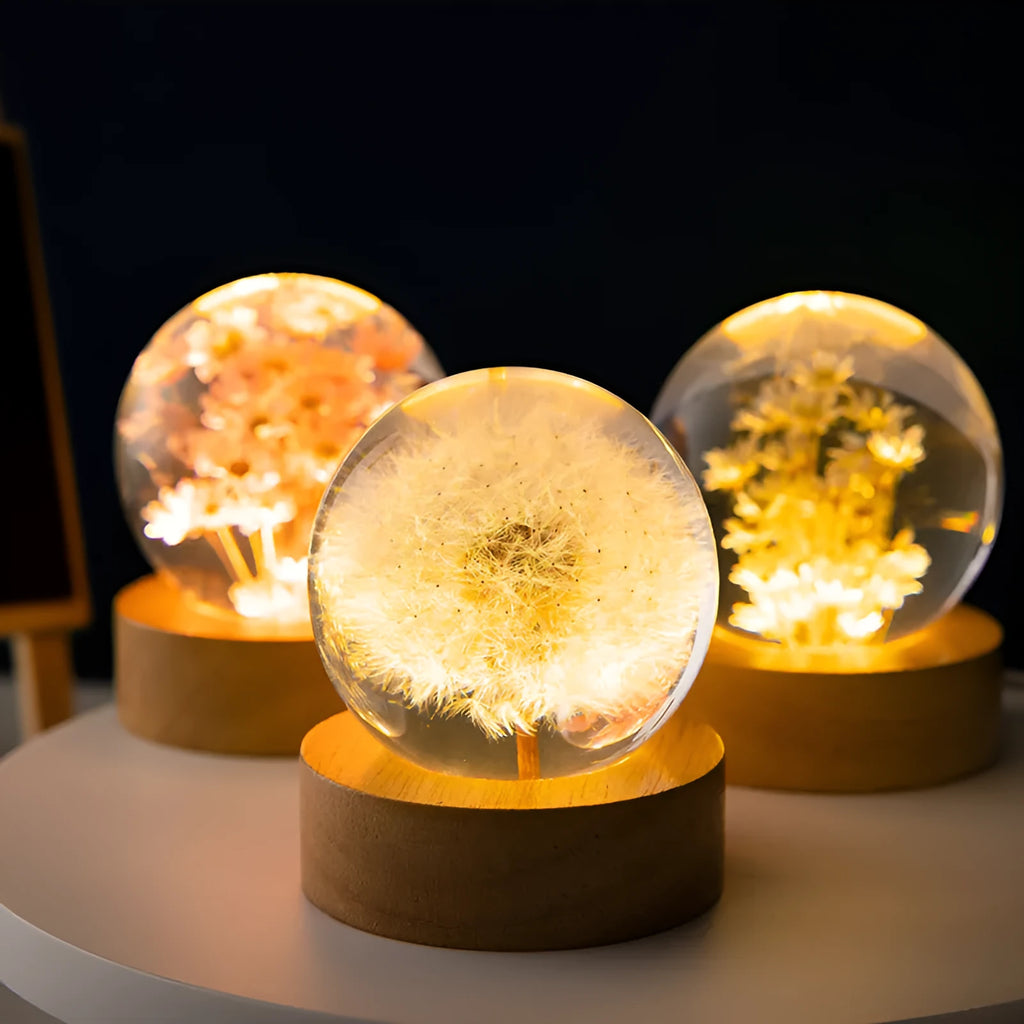 Preserved dandelion inside a glowing resin crystal ball night light on a beech wood stand.