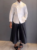 Women's white asymmetric hem shirt and black pleated trousers co-ord set in polyester
