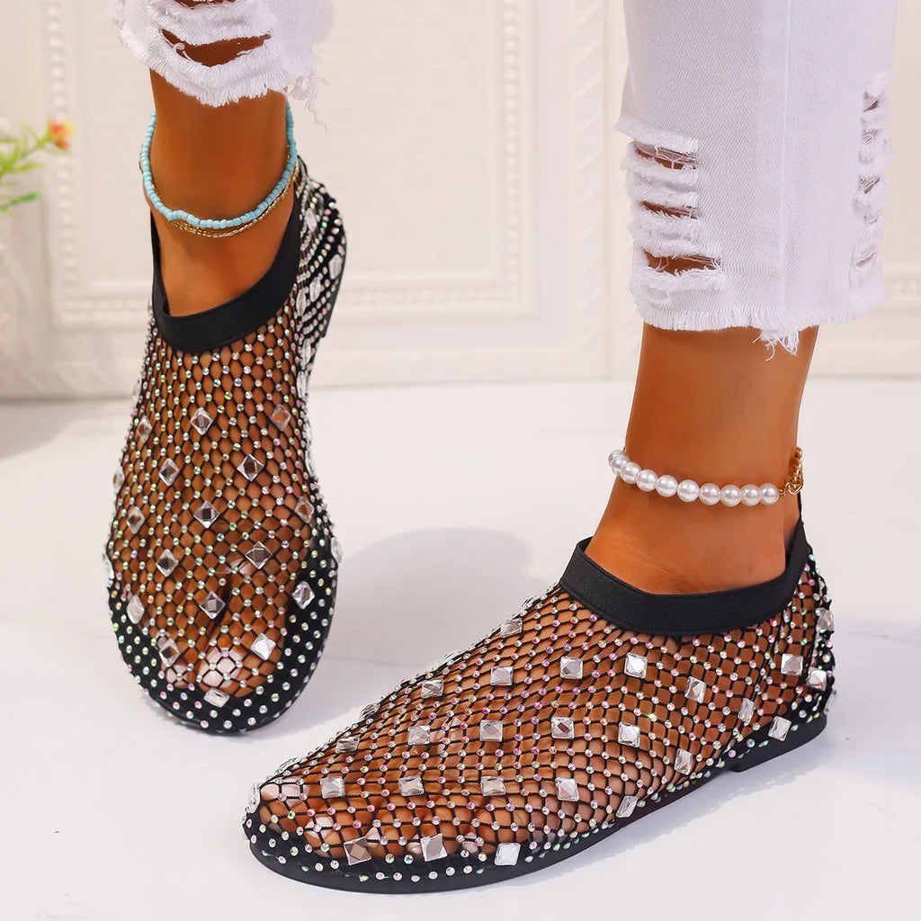 Women's white mesh flat sandals with colourful rhinestone decoration and a rubber sole.