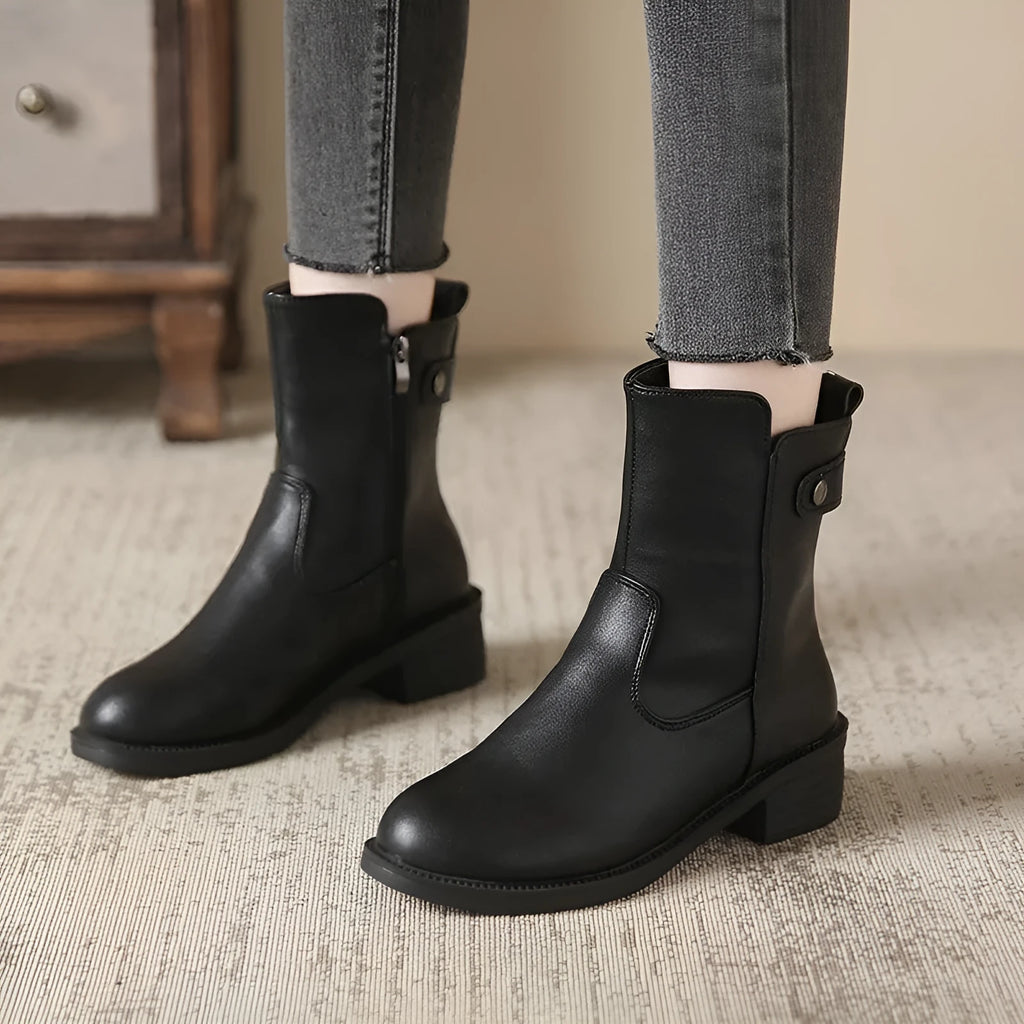 Black women's ankle boots with side zip and low round toe on a rubber sole.