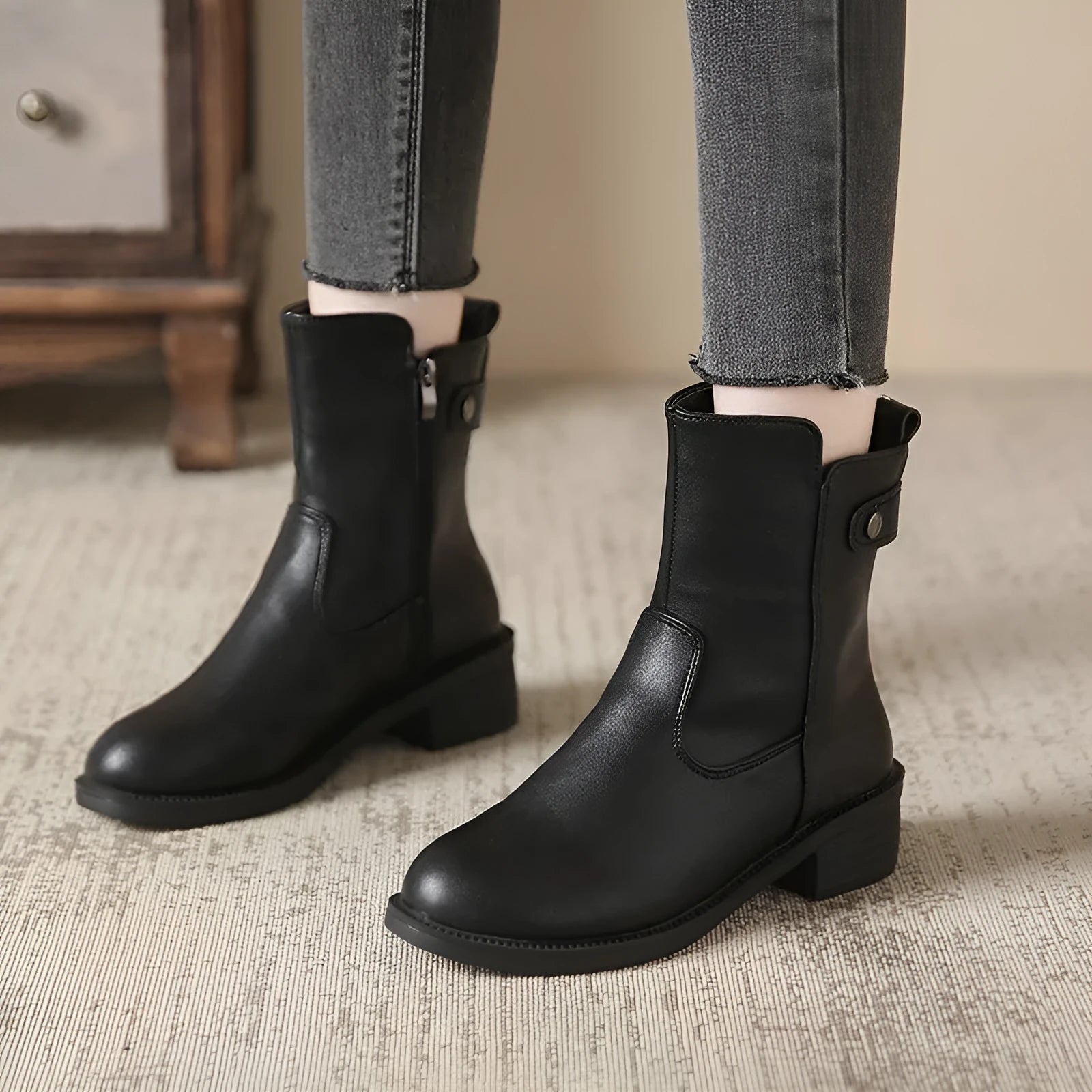 Black women's ankle boots with side zip and low round toe on a rubber sole.