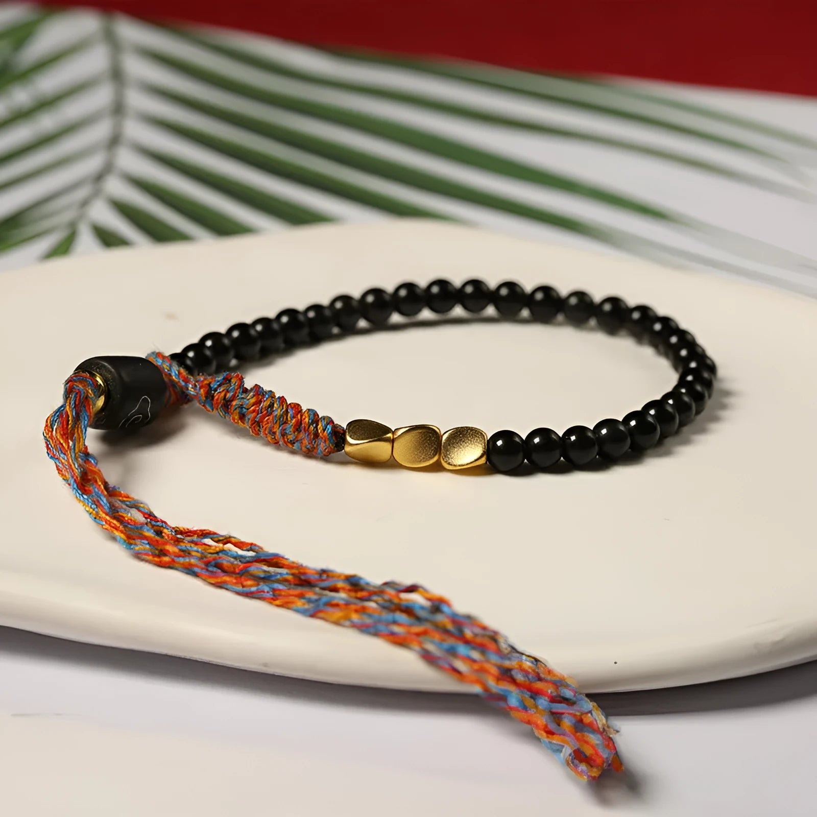 Hand-woven obsidian carrying strap bracelet showing textured surface and dark colour