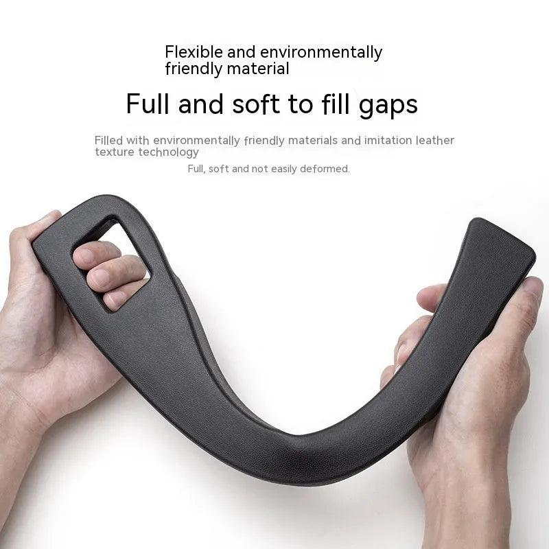 Black plastic car seat gap storage box with removal handle inserted between vehicle seats
