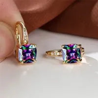 Geometric copper ear hook with round element and inlaid square zircon stone, shown in a golden colour.