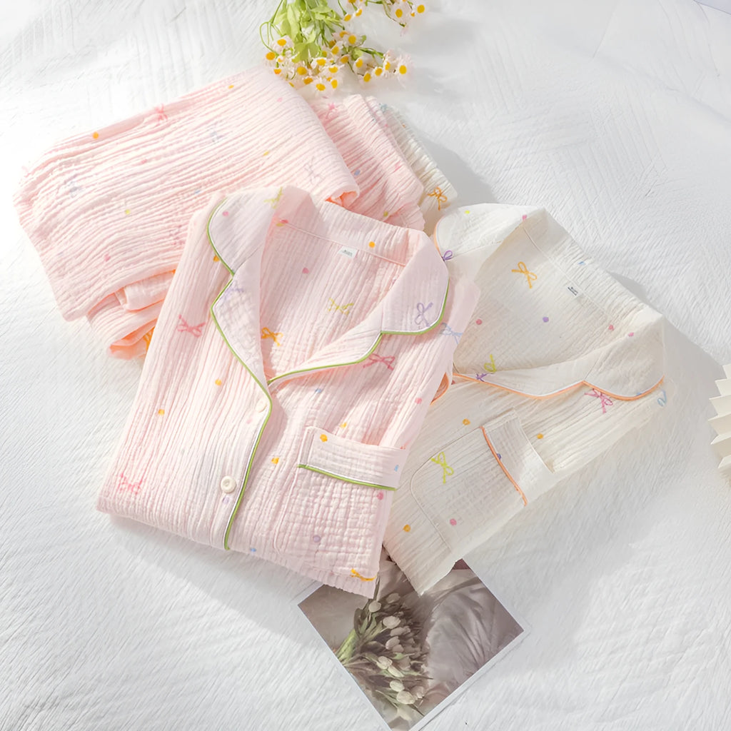 Women's pink cotton long sleeve pajama top and trousers set on hanger.