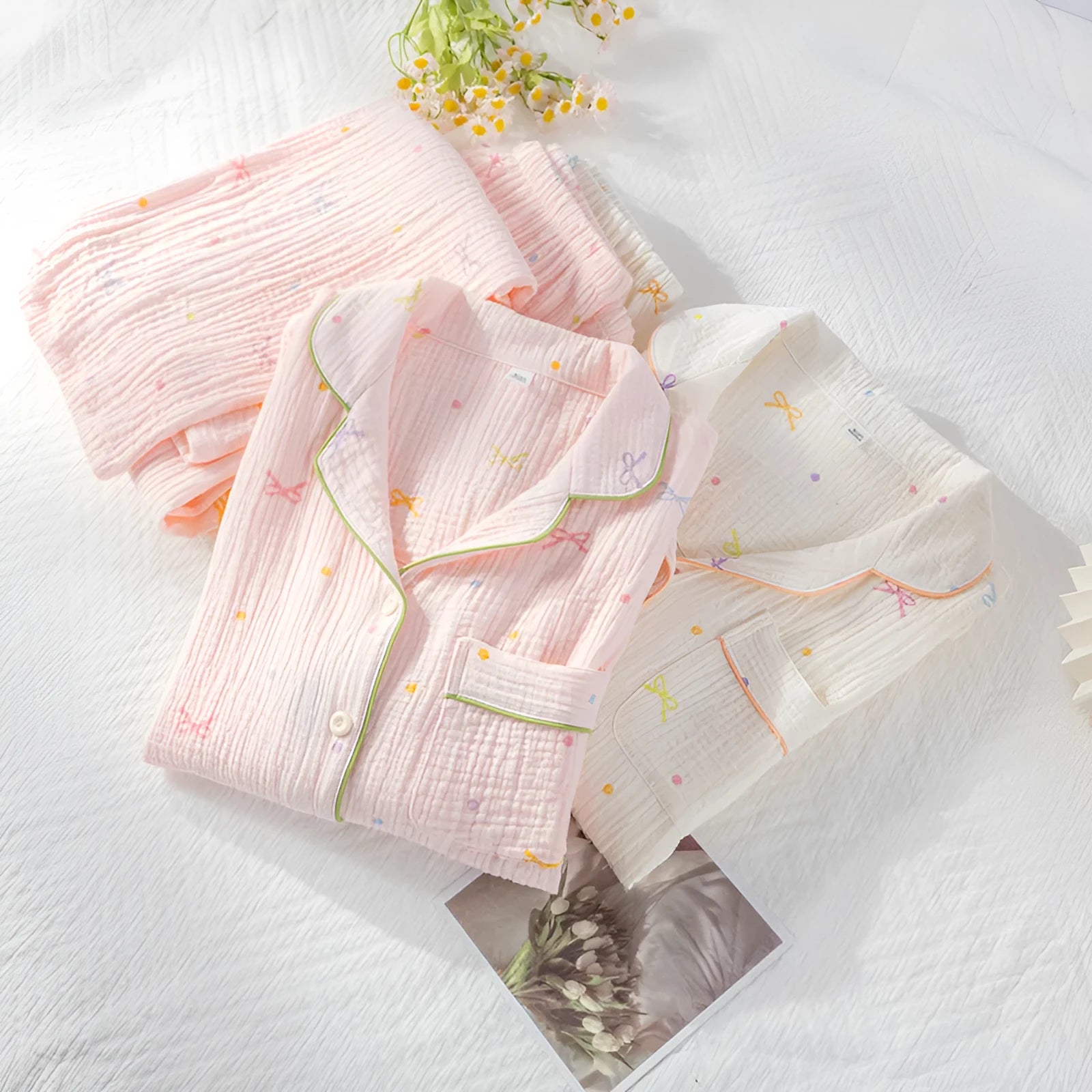 Women's pink cotton long sleeve pajama top and trousers set on hanger.