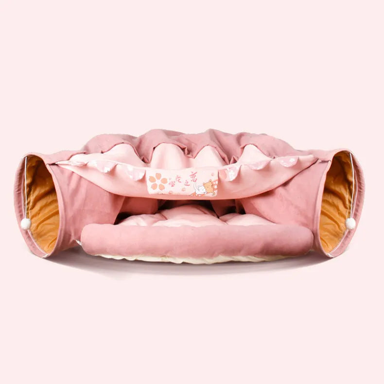 Collapsible cloth cat tunnel folded flat next to a cat, showing Coffee colour option.