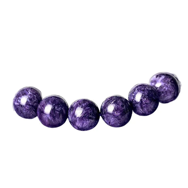 Natural transparent charoite crystal bracelet with platinum elements on a wrist.