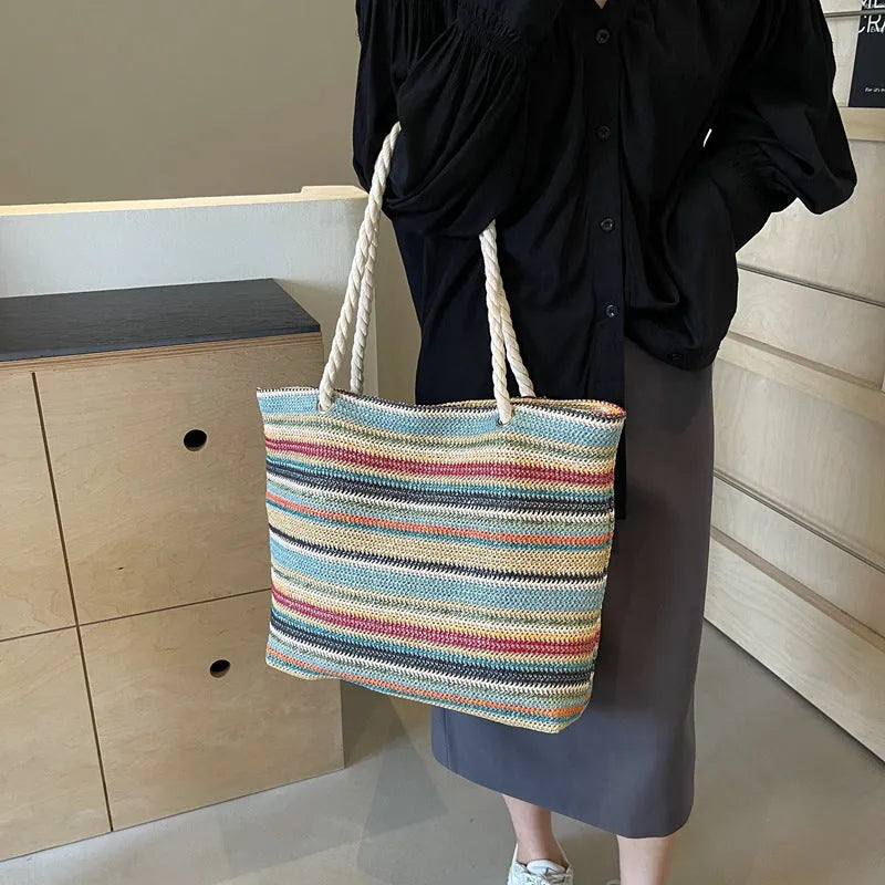 Blue woven straw-effect nylon shoulder bag with a single strap and large main compartment.