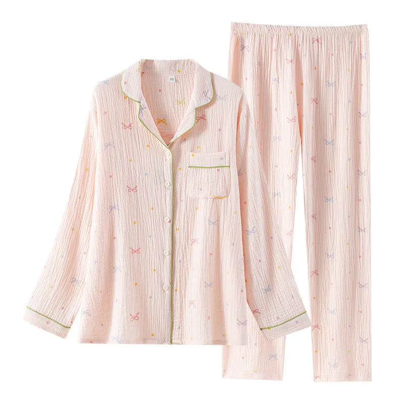 Women's pink cotton long sleeve pajama top and trousers set on hanger.