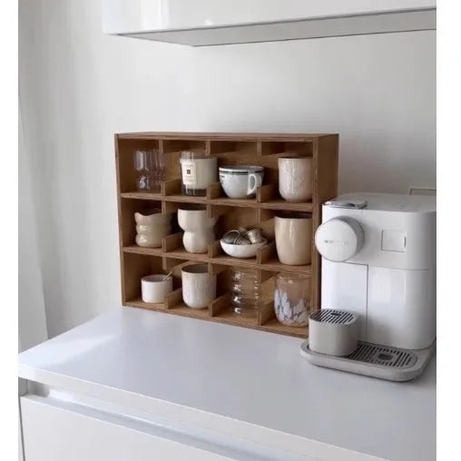 Square solid wood storage rack with multiple grid compartments for cups in a birch wood finish.