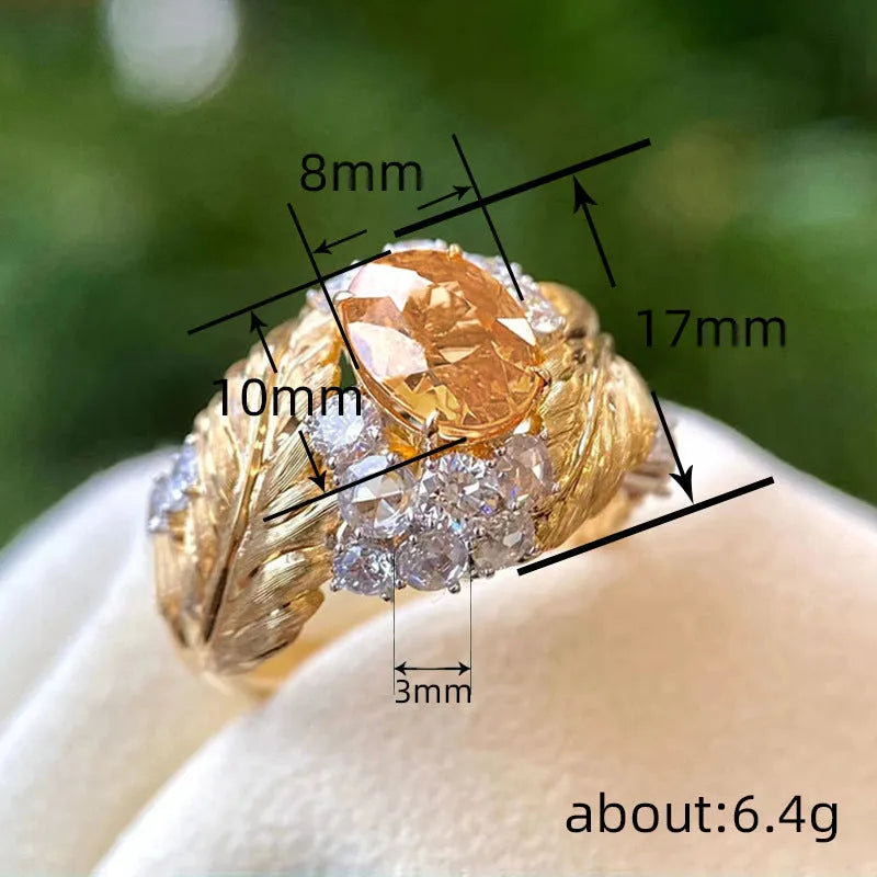 Gold-coloured copper ring with embossed feather pattern and yellow zircon stone