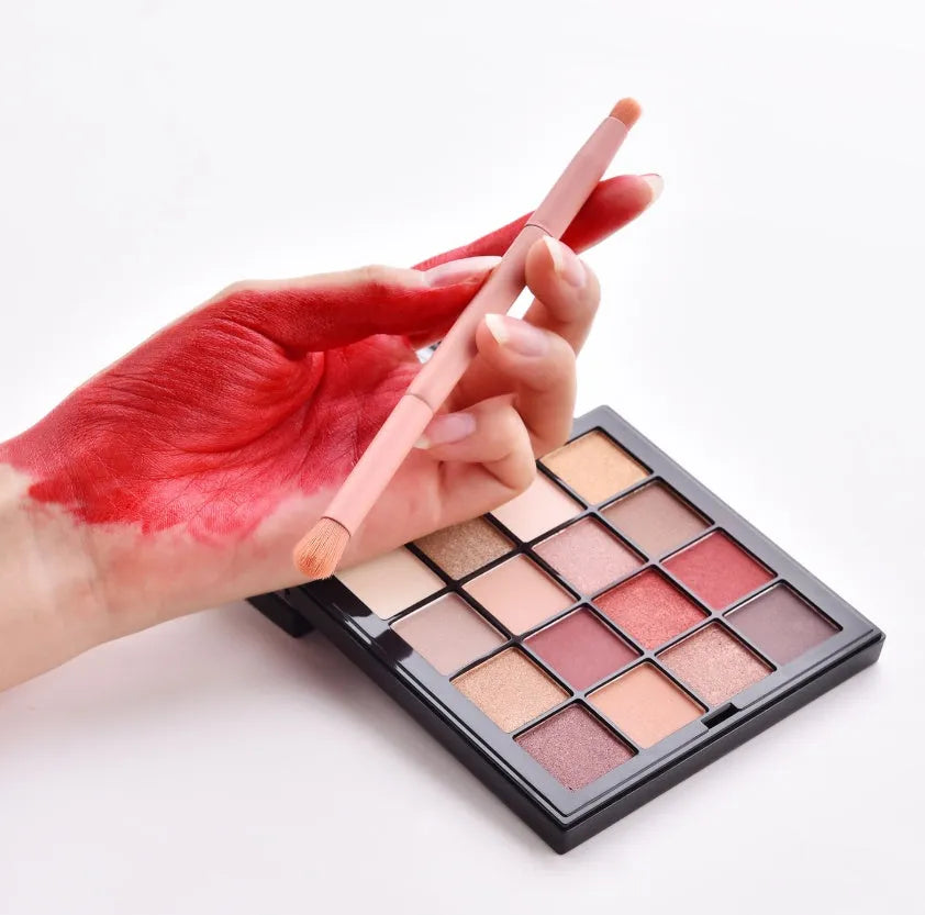 Ten professional makeup brushes with wooden handles arranged in a set, including powder, foundation and detail brushes