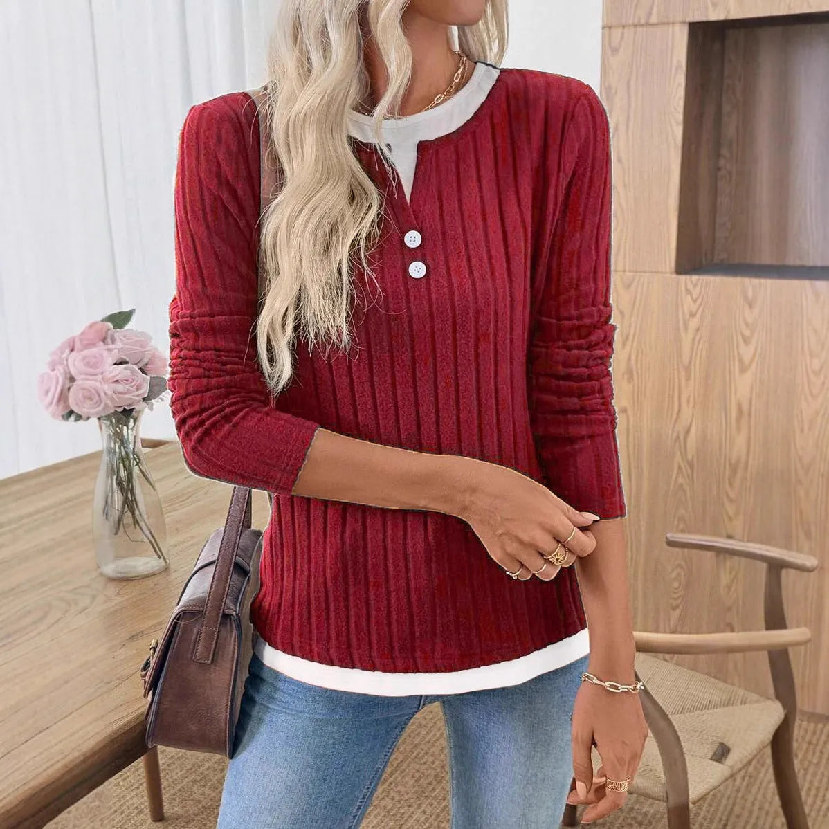 Women's black grinding stripe fake two-piece pullover sweater with round neck and button detail.