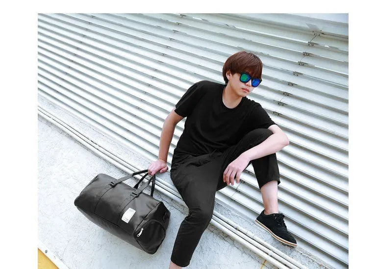Black waterproof sports duffel bag with separate shoe compartment and diagonal shoulder strap