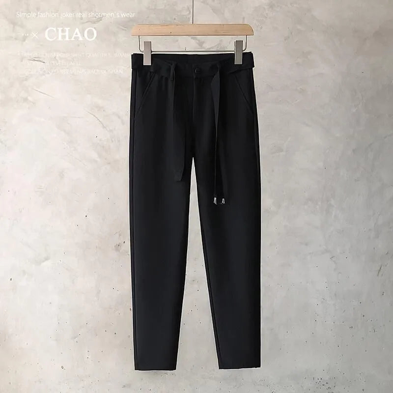 Boy wearing slim straight grey wool trousers with a tapered fit and straight leg opening.