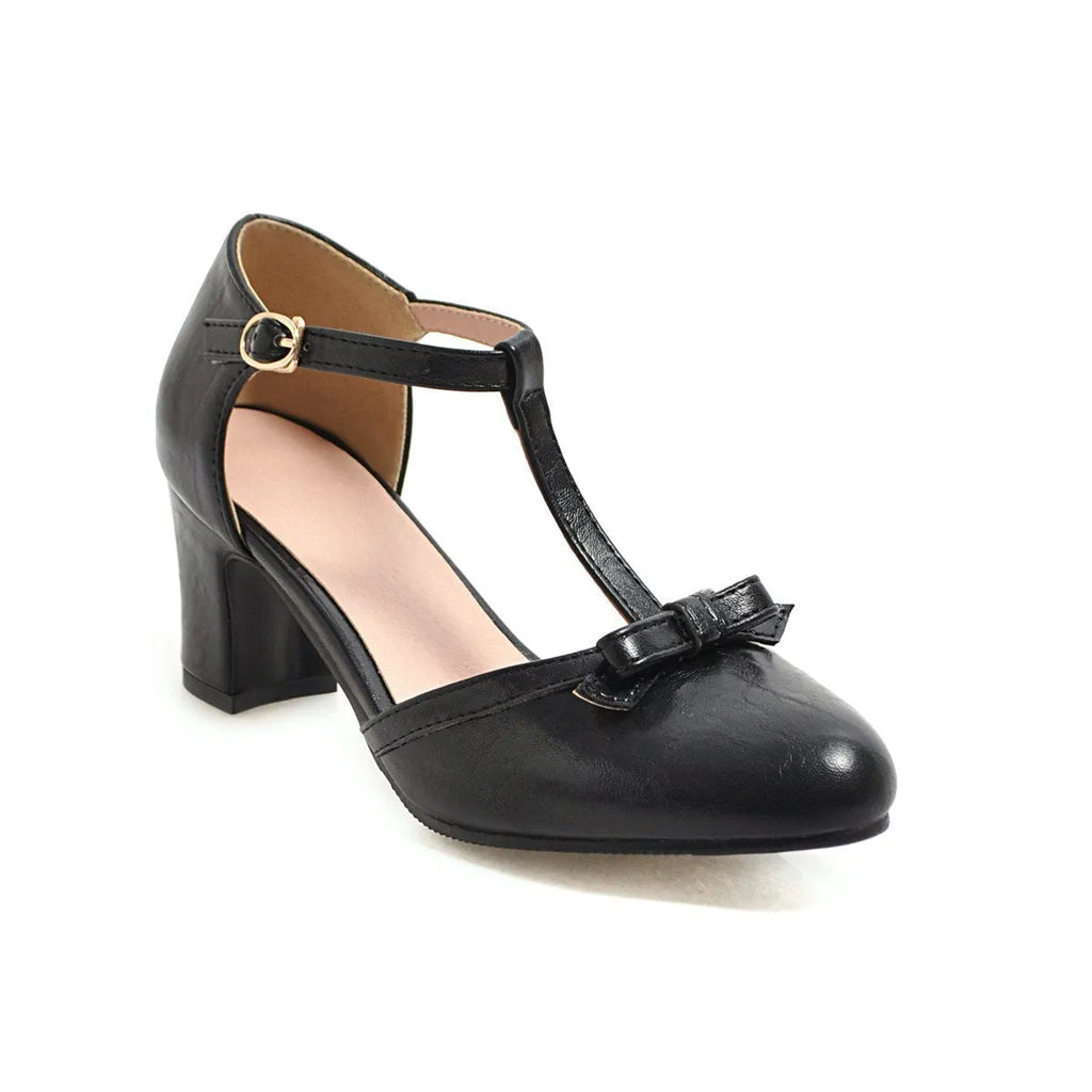Women's apricot chunky heel sandals with a hollow-out round toe, T-strap buckle, and a black bow detail.