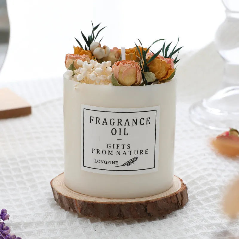 Aromatherapy candle with dried flowers embedded in wax, shown with optional wooden chip base and gift box.