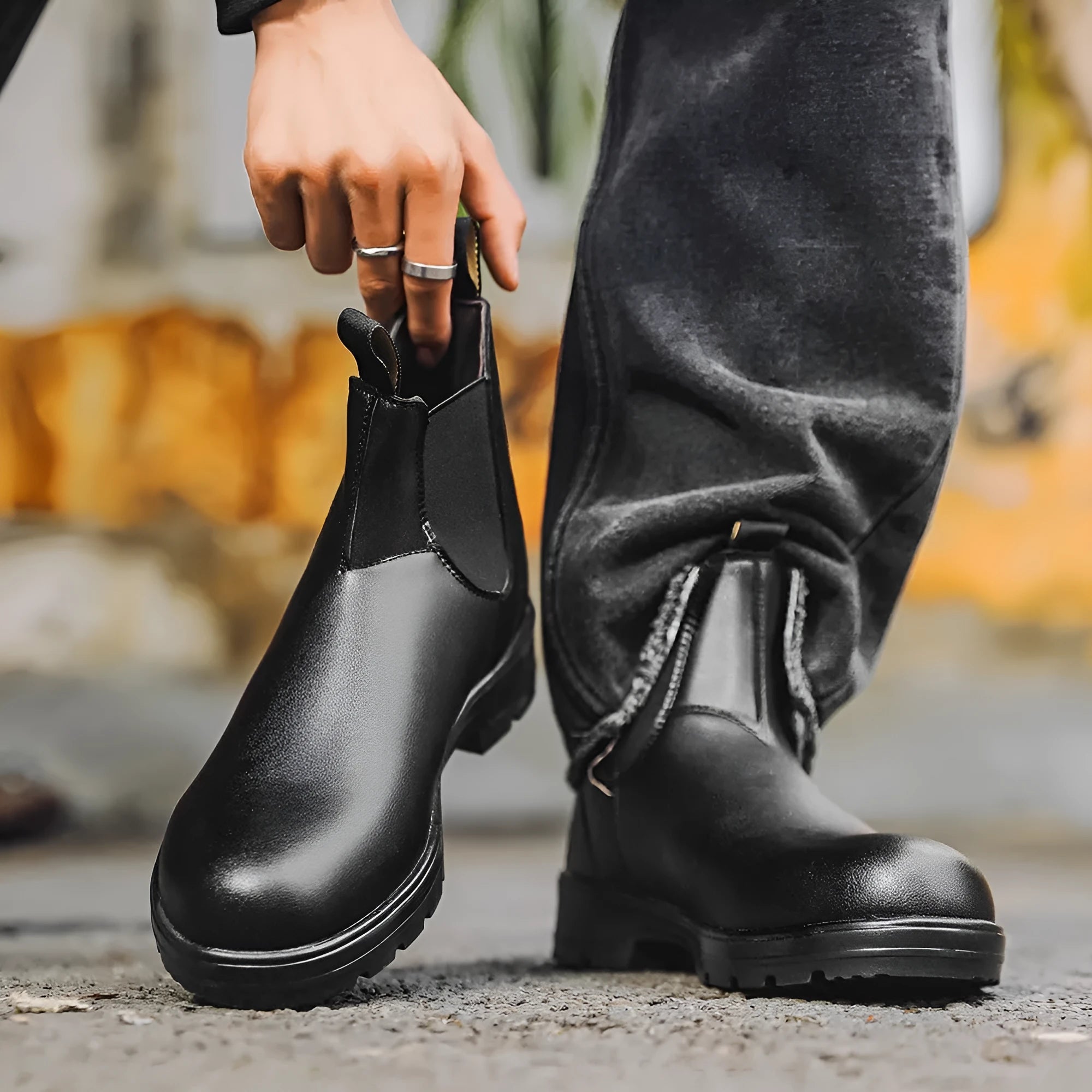 Vintage brown frosted finish Chelsea boots with car suture detailing on a wooden floor.