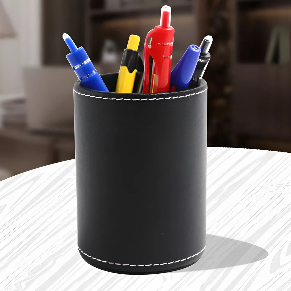 Black leather round pen holder with cylindrical shape on a desk