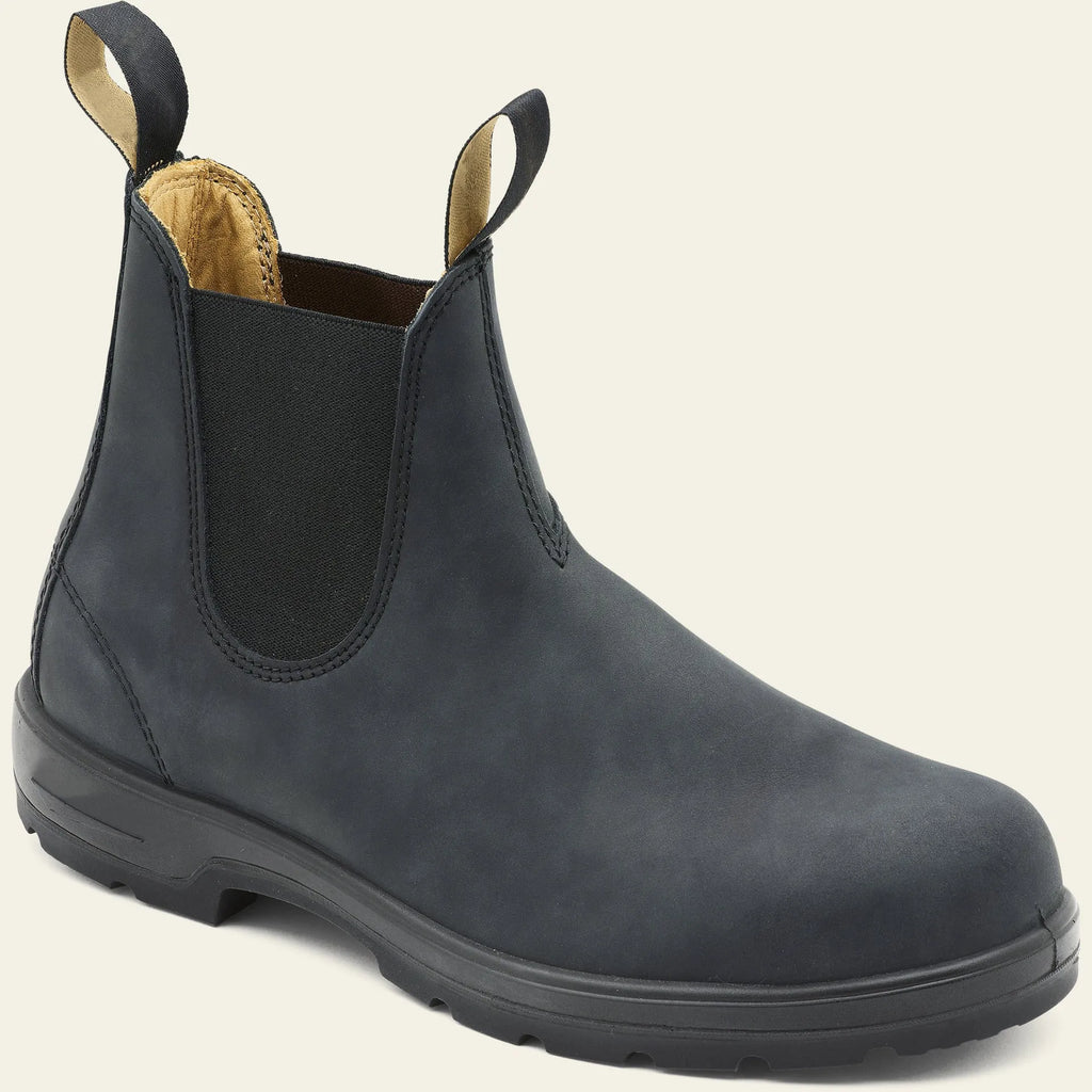 Vintage brown frosted finish Chelsea boots with car suture detailing on a wooden floor.
