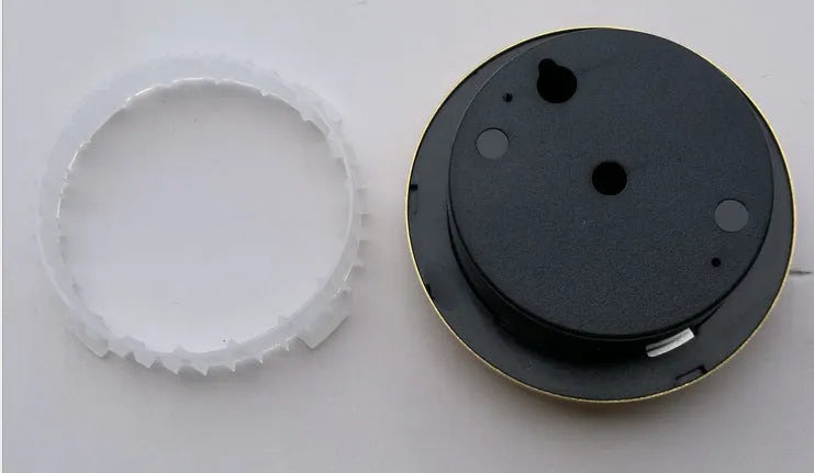 Analog thermometer and hygrometer with silver aluminum outer ring and dial on a white background