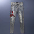 Distressed slim fit jeans with embroidered patches and washed-out vintage colour