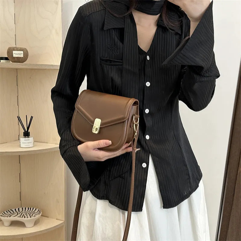 Soft PU messenger bag with textured finish and clamshell opening in horizontal square shape