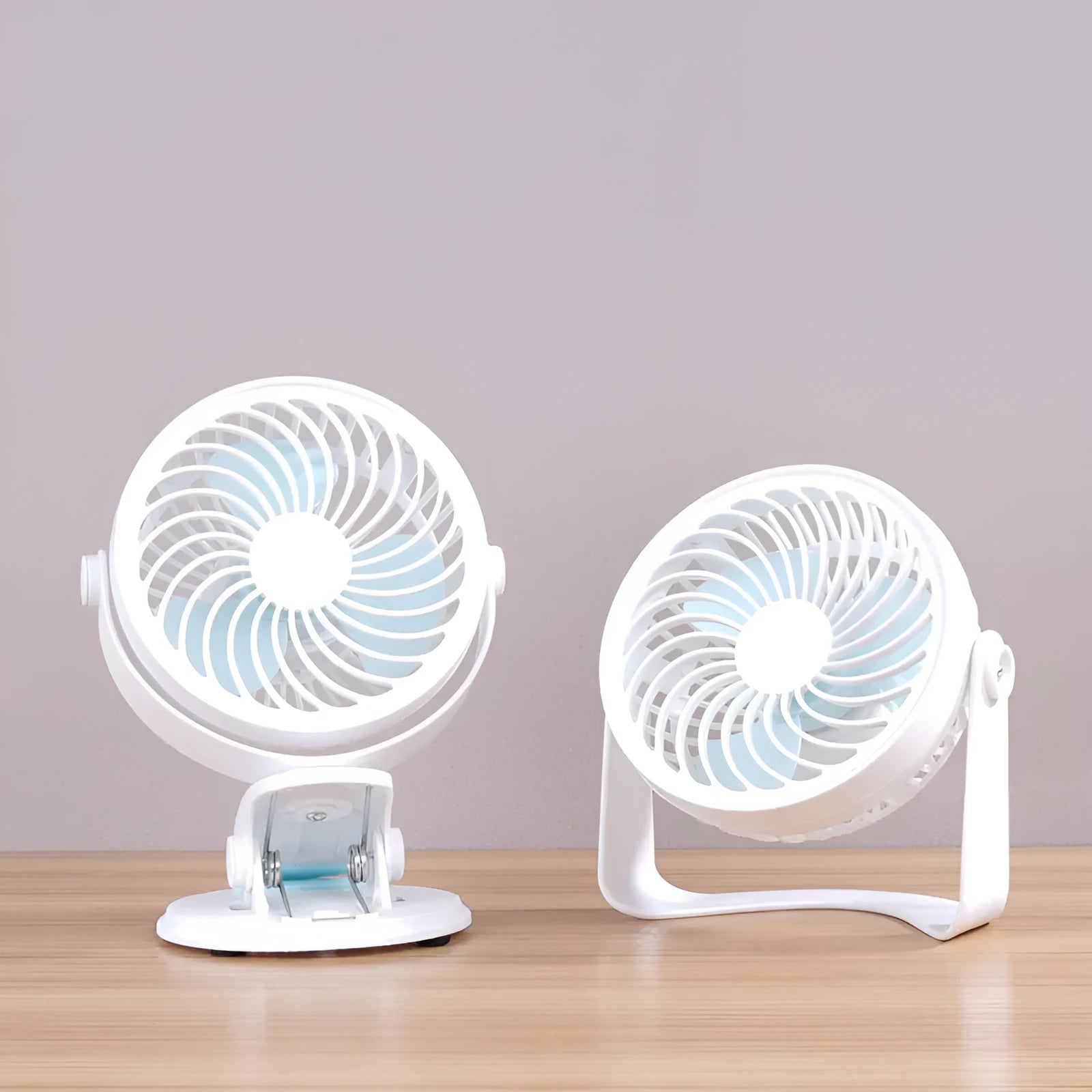Small white USB desktop fan with clip attached to a desk edge, showing three blades.