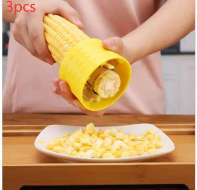 Yellow corn-shaped manual corn grinder thresher kitchen gadget on a wooden surface