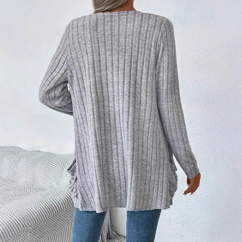 A woman's loose-fit long sleeve cardigan in Grandad Grey with pockets, shown on a hanger.