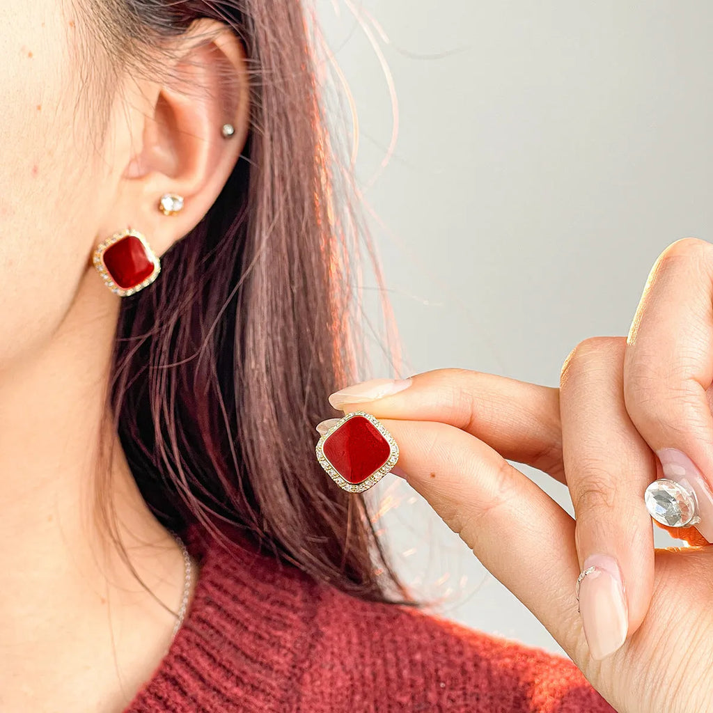 Red geometric square earrings with inlaid design details on alloy material