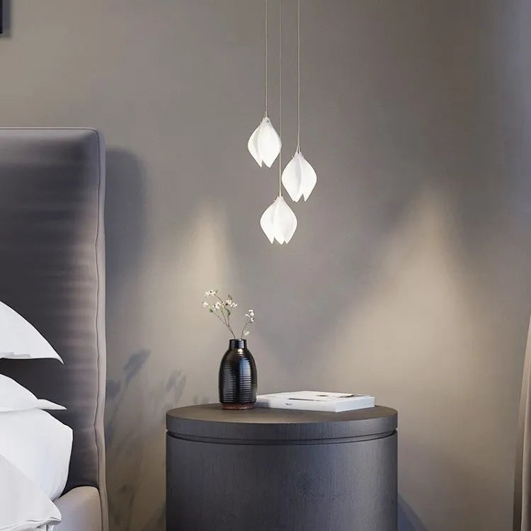 Ceramic magnolia petal-shaped single head pendant light with a dimmable fitting against a neutral background.