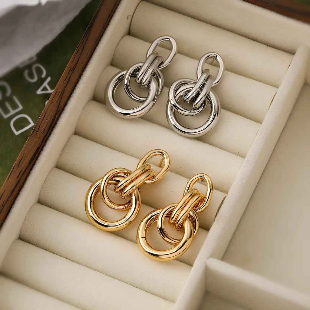 Geometric gold-coloured copper earrings with irregular design elements and high-profile construction