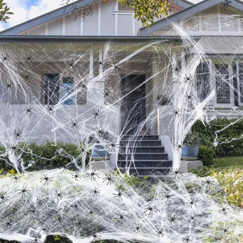 White cotton spider web Halloween decoration bundle with plastic spiders scattered on a dark background.