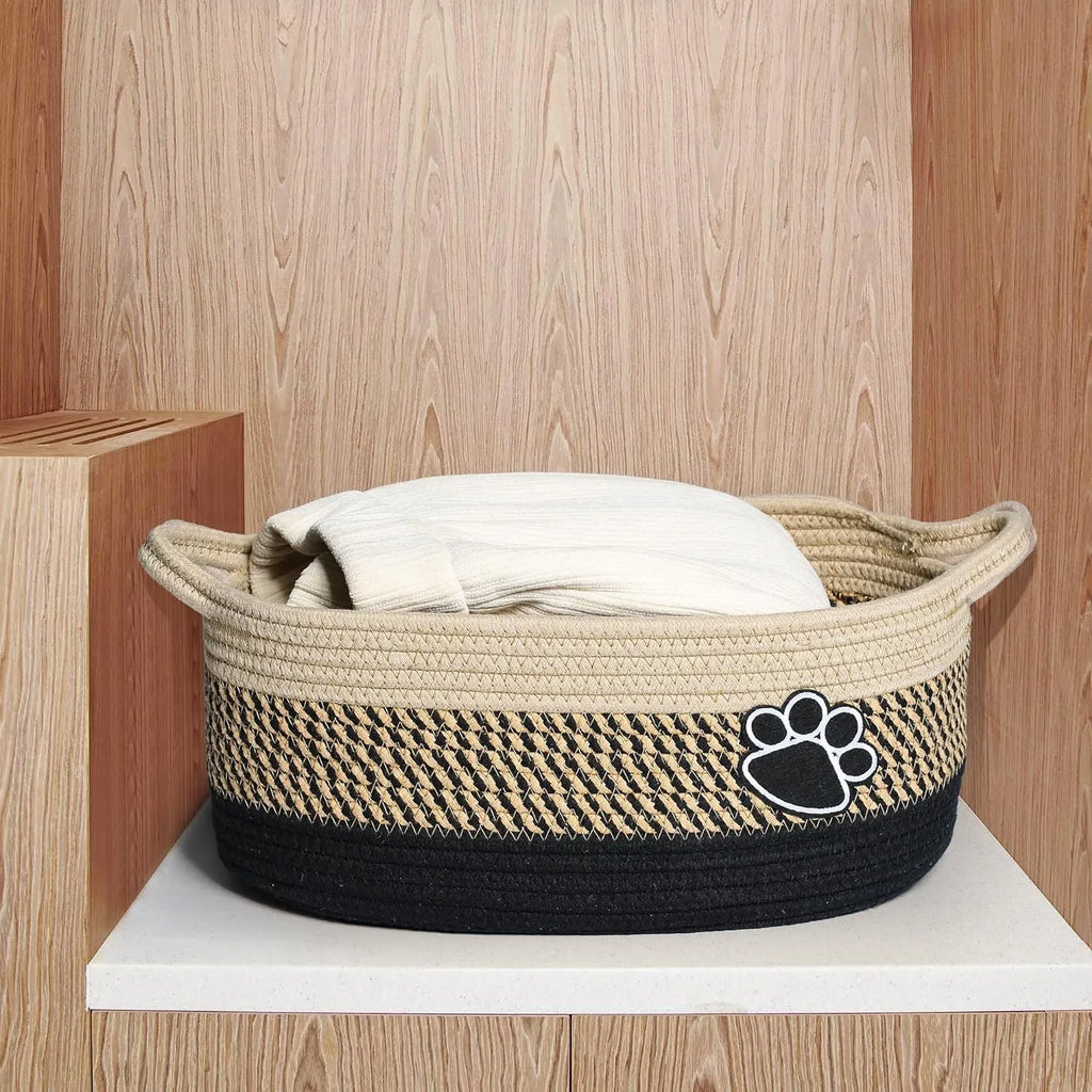 Light beige handmade cotton rope woven storage basket with wooden accents and handles.