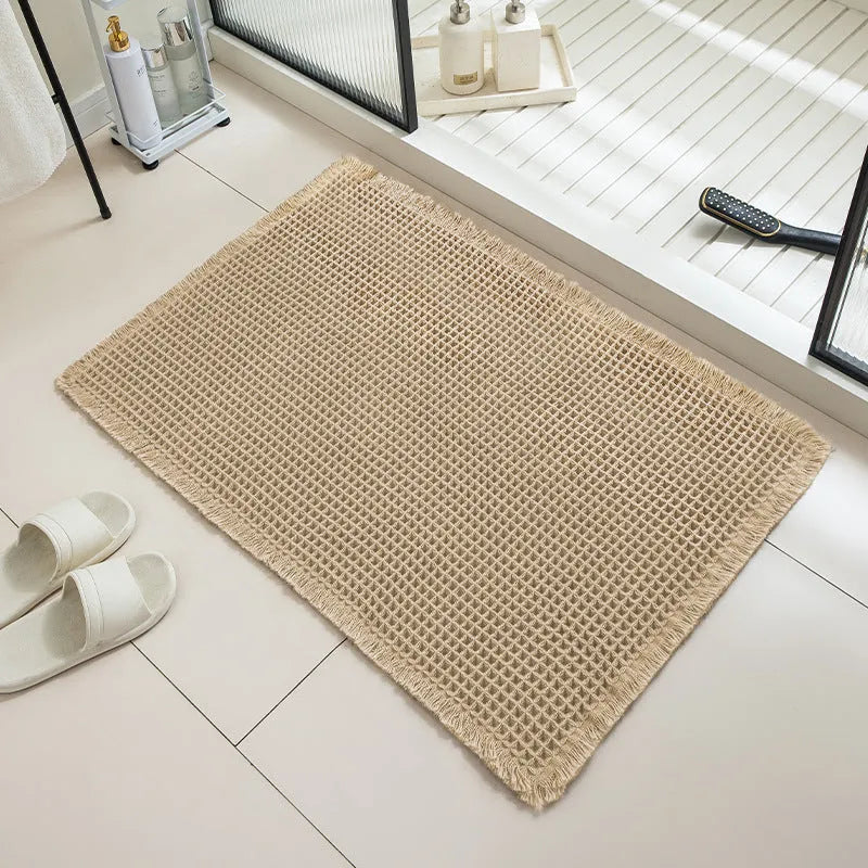 Square checkered polyester bathroom carpet on a tiled floor in a light grey colour.